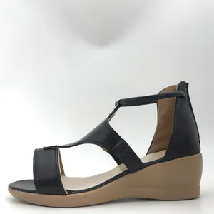 Vue latérale d'une sandale compensée rétro en cuir noir avec boucle en T