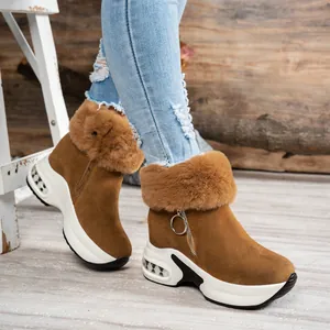 Detail view of brown suede snow boots with fluffy faux fur and platform sole.