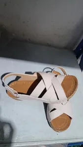 Vue détaillée de sandales compensées beige avec brides croisées et semelle piquée