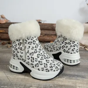 Close-up of leopard print snow boots with white faux fur trim and platform sole.