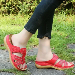 Sandales compensées rouges pour femmes avec découpes et bandes velcro ajustables.