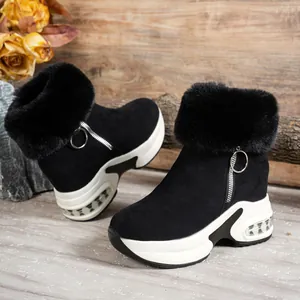 Side view of black suede snow boots with faux fur collar and platform wedge sole.