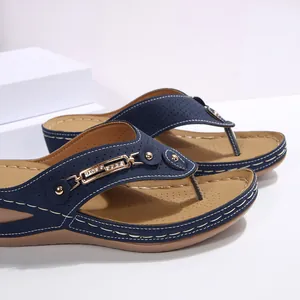 Primer plano de sandalias con cuña azul marino con decoración de hebilla de pedrería