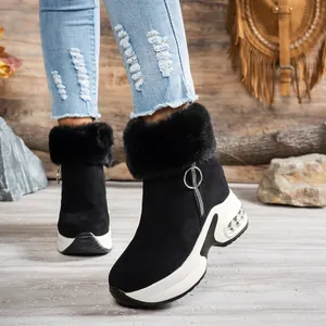 Detail of women's black platform snow boots with faux fur collar and side zipper