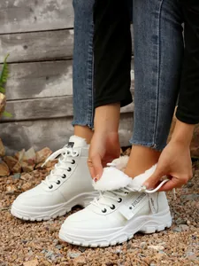 Dettaglio di sneaker alte invernali bianche con calda fodera in morbida pelliccia