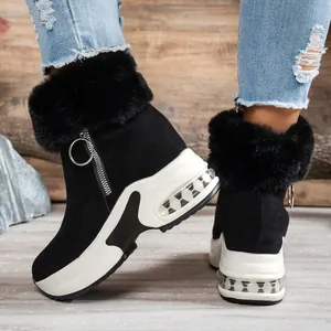 Close-up detail of women's black platform snow boots with faux fur and side zipper.