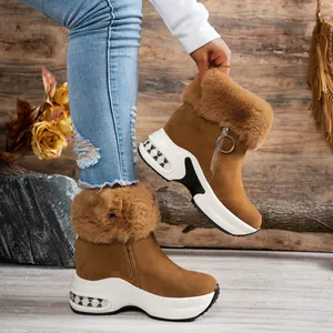 Close-up of brown suede winter boots with faux fur trim and platform soles.