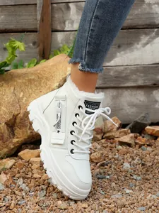 Dettaglio di sneaker alte bianche foderate in pile con cerniera laterale e lacci