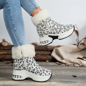 Close-up of women's leopard print snow boots with platform wedge sole and faux fur trim