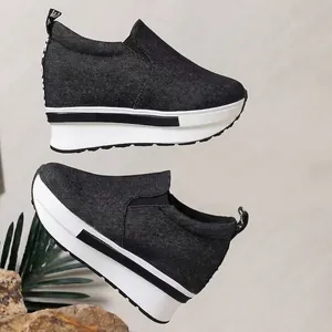 Zapatillas de plataforma de mezclilla negra para mujer con suela blanca gruesa y moderna.