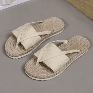 Detailansicht beige geflochtene Strand-Flip-Flops mit breiten Wickelriemen aus Stoff