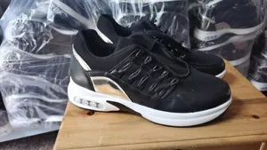 Seitenansicht schwarzer Damen-Sneaker mit goldenen Akzenten und weißer Sohle.