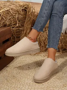 Detail of cozy beige faux-suede flat snow boots with warm plush lining and round toe
