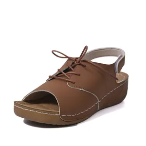 Side view of brown platform fish-mouth sandals with lace-up detail and velcro strap.