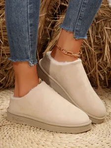 Detailed view of beige faux suede fur-lined winter slippers with cozy lining and flat soles
