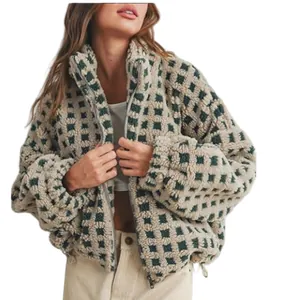 Close-up detail of a stylish green and beige checkered fleece jacket with high collar