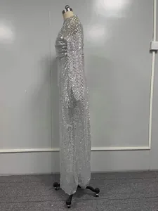 Vue latérale d'une élégante robe de soirée à paillettes argentées et manches longues