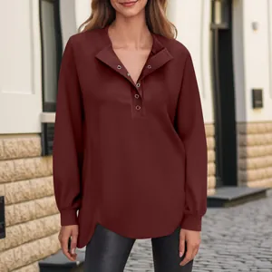 Detailweergave van een bordeauxrode top met lange mouwen en knoopsluiting op model