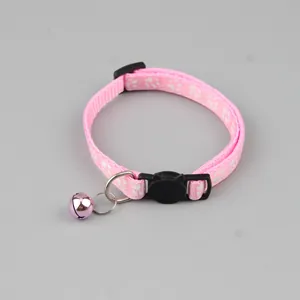 Detail van roze kattenhalsband met bel, pootafdrukken en een gesp in de vorm van een kat