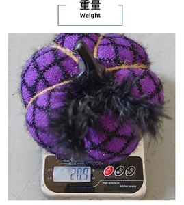 Close-up detail of a 209g purple handmade knitted Halloween pumpkin ornament on a scale.