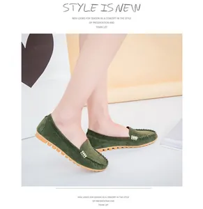 Detailed side view of dark green suede-like flat loafers with gold metal buckle