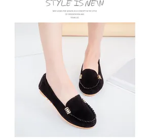 Detailed view of black suede flat loafers with elegant gold buckle and soft sole