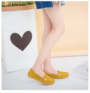 Yellow suede-like flat loafers with metal buckle shown in a lifestyle indoor setting
