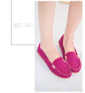 Detail of fuchsia suede-like loafers with decorative metal buckle and stitching.