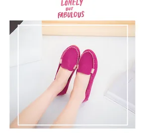 Detailed view of fuchsia suede loafers with decorative metal buckle and round toe.