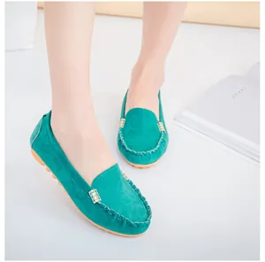 Teal suede women's loafers with metal buckle detail shown on model's feet