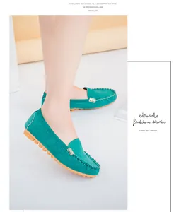 Close-up detail of green suede loafers with gold buckle and moccasin stitching