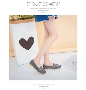 Stylish grey suede round-toe loafers with metal buckle decoration worn by model