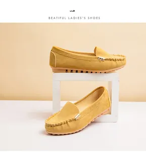 Detailed view of yellow suede flat loafers for women with a stylish gold metal buckle