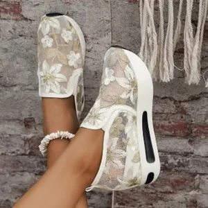 Close-up of breathable white mesh platform shoes with elegant floral embroidery