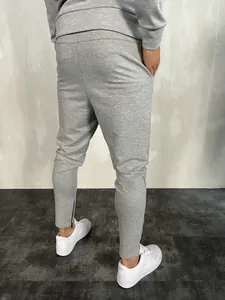 Vista posteriore di pantaloni sportivi grigi slim fit da uomo con zip alle caviglie
