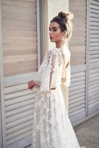 Elegante abito da sera in pizzo bianco con profondo scollo a V e raffinato design senza schiena
