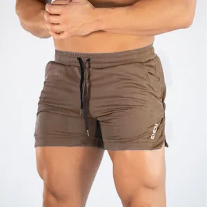 Close-up of men's brown quick-dry gym shorts showing fabric texture and EHCM logo