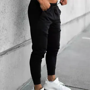 Side view of slim-fit men's black athletic joggers with ribbed cuffs and drawstring.