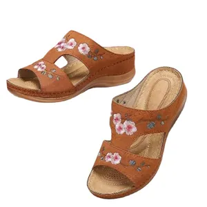 Sandales compensées vintage marron avec broderie florale sur fond blanc net.