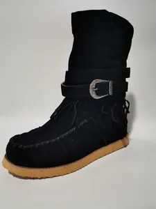 Close-up of women's black suede winter boots with fringe and silver buckle detail