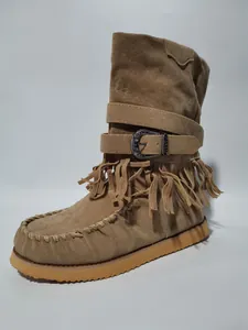 Close-up of tan suede fringe boot with vintage metal buckle and decorative stitching