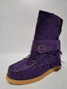 Macro view of detailed purple suede fringe boot featuring an ornate silver buckle accent