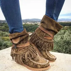 Close-up view of bohemian style brown suede fringe winter ankle boots with straps