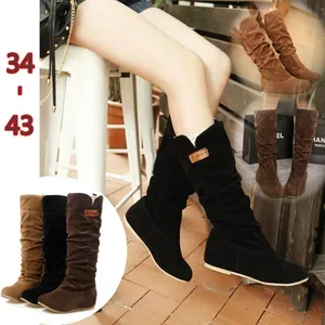 Detailed view of mid-calf women's slouch boots with flat soles and soft suede texture