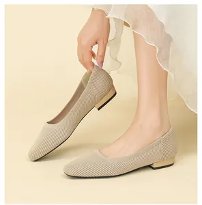 Dettaglio di ballerine in maglia beige che mostra il tessuto e il tacco basso dorato.