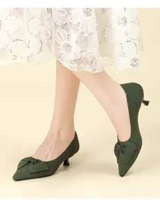 Détail de chaussures à talons chaton en maille vert foncé avec un nœud élégant