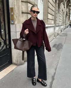 Detailopname van een stijlvol bordeauxrood wollen jasje in Franse stijl gedragen door model
