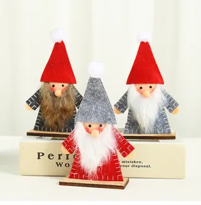 Close-up of three handmade wooden Christmas gnome ornaments with felt hats and fur beards.