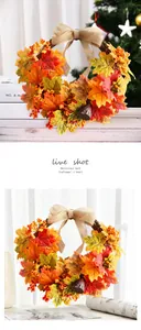 Detailed view of artificial autumn maple leaf wreath with burlap bow and red berries