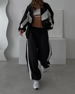 Full shot of a stylish black and white color-block tracksuit set with a zip-up jacket.
